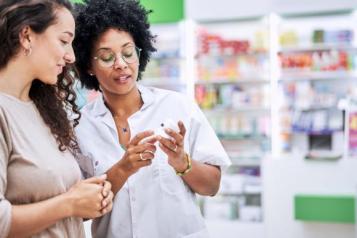 Two women looking at a pharmacy.