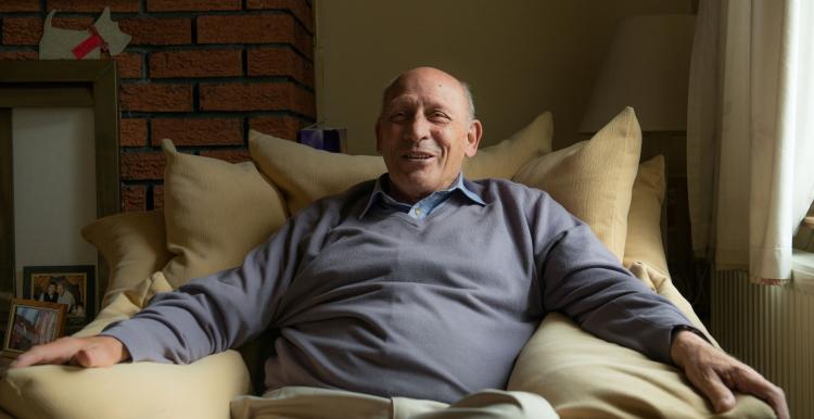 Man sitting in armchair in his home.