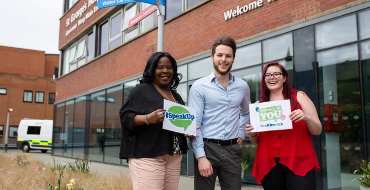 Group of Healthwatch volunteers outside a hospital holding 'Speak up' sign