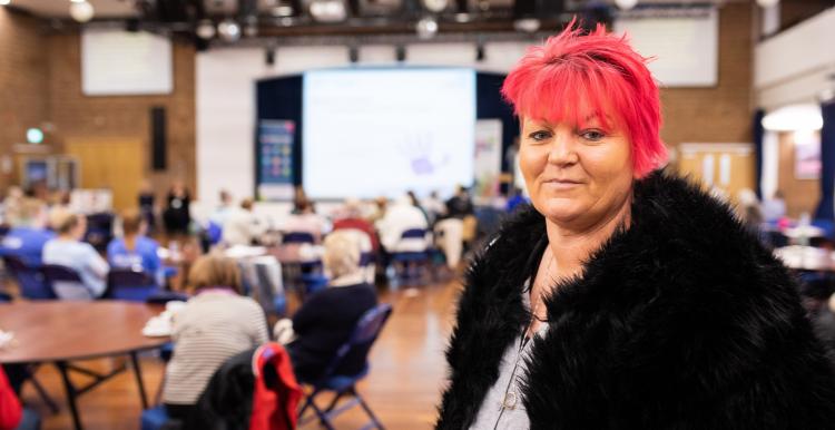 woman with short pink hair looks into camera