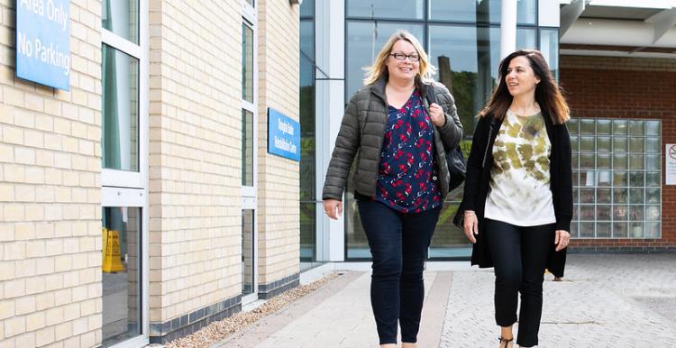 Two women walking outside hospital