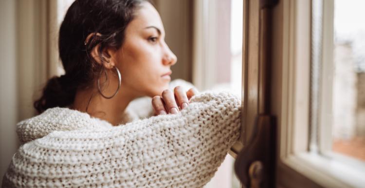 Woman looks out of a window