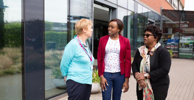 Three women talking outside hospital