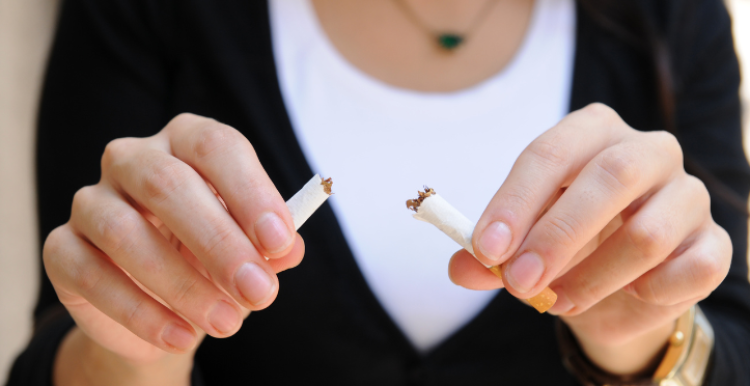 Person breaking cigarette in two