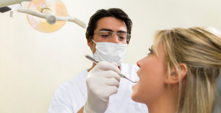 Dentist wearing protective face covering with patient