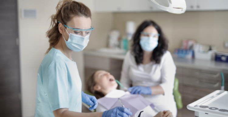 Dentists wearing protective face covering with patient