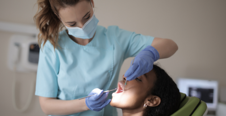 Dentist wearing protective face covering with patient