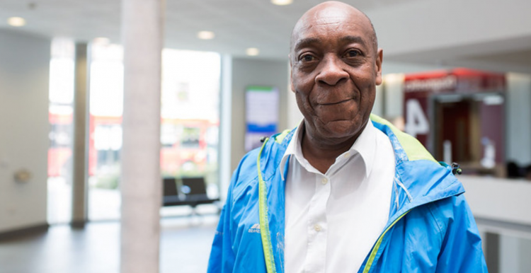 Older black man standing at a hospital ward