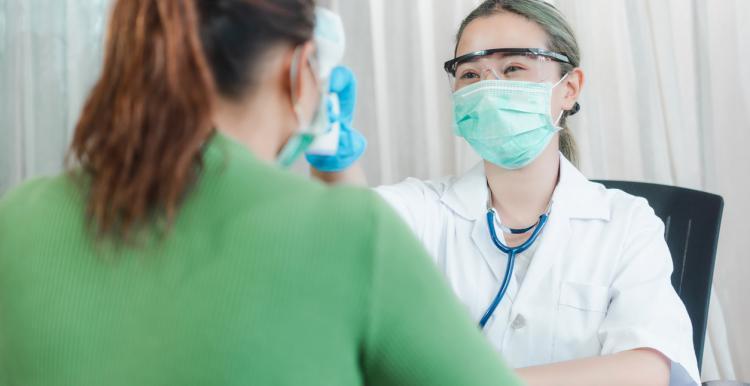NHS dentist wearing face covering and treating a patient
