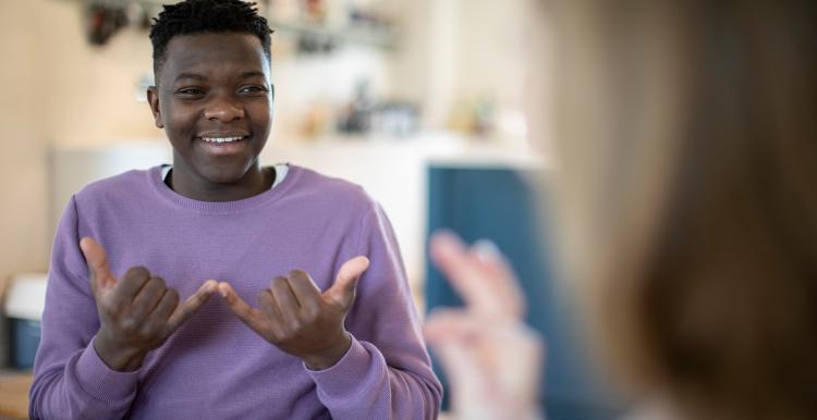 Teenage girl and boy having conversation using sign language