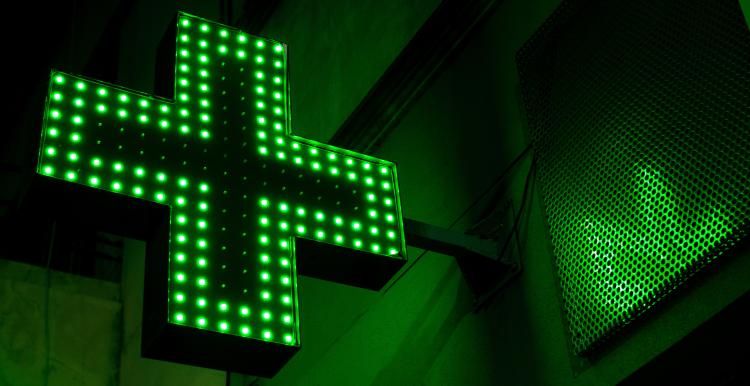 Pharmacy sign at night lit up in green