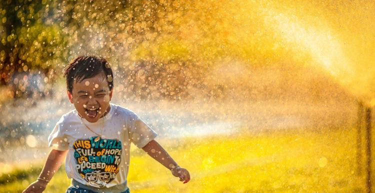Photo by Mi Pham on Unsplash - Boy runs through sprinkler