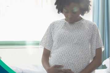 Pregnant lady sitting on hospital bed