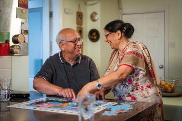 Man and woman at a table completing a puzzle.
