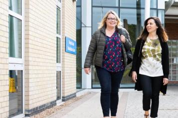 Two women walking outside hospital