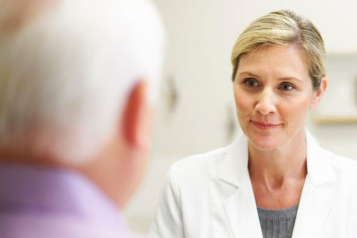 Female doctor talking to an older male patient