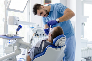 Dentist treats a patient in bright room