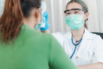 NHS dentist wearing face covering and treating a patient