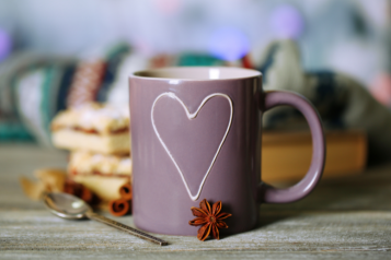 a mug with a hear shape on it on a cosy autumn background