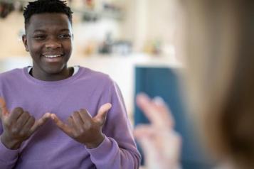 Teenage girl and boy having conversation using sign language