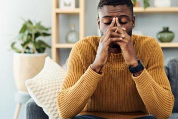 Man sits on sofa and holds his head in his hands. (Representative Photo)