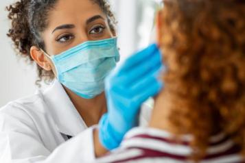 Medical professional wearing a COVID masks treats patient