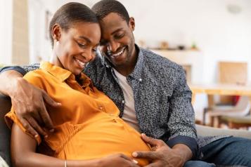 Pregnant woman sitting on a sofa with her partner