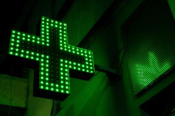 Pharmacy sign at night lit up in green