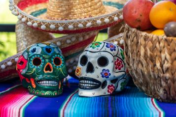 A colourful arrangement of decorative sculls, baskets and hats to celebrate the mexican Day of the Dead
