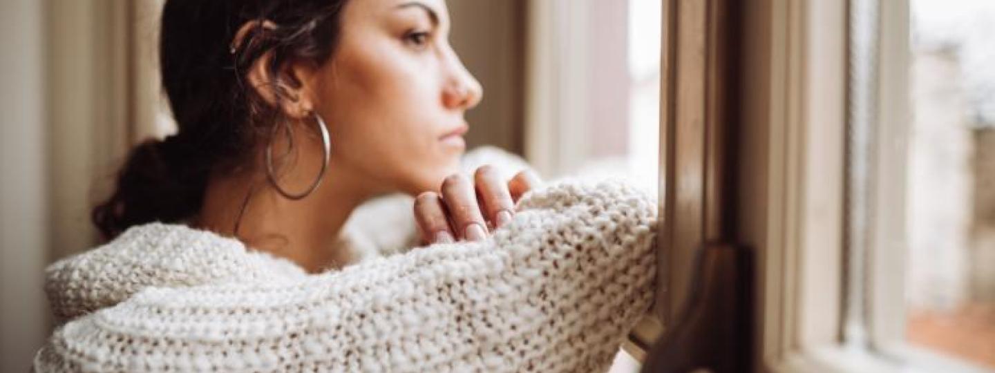 Woman looks out of a window