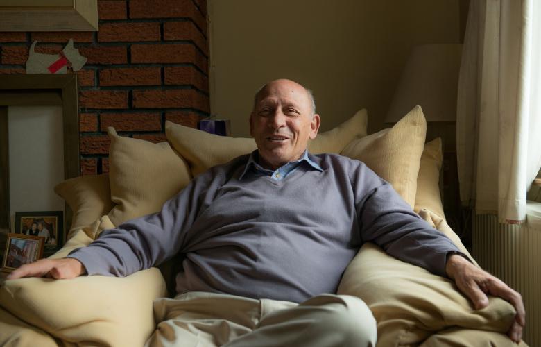 Man sitting in armchair in his home.