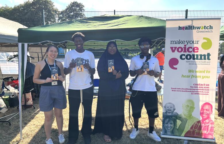 Healthwatch Greenwich young person's researchers standing in front of a stall holding leaflets about the HPV vaccine.