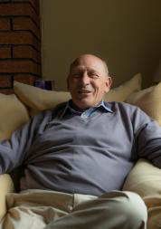 Man sitting in armchair in his home.