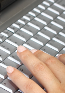 Close up of hands typing on a laptop keyboard Close up of hands typing on a laptop keyboard